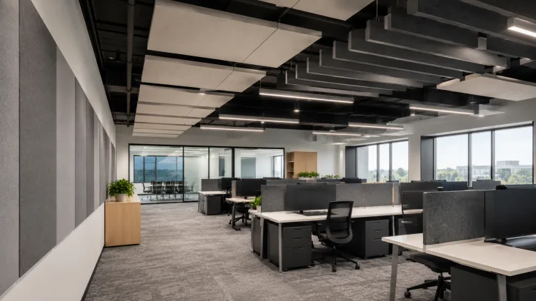 Open-plan office with suspended acoustic ceiling clouds and wall panels
